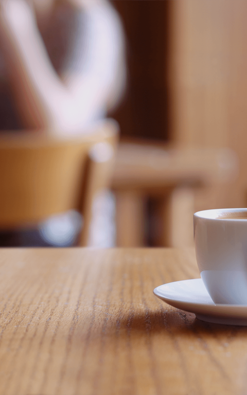Een kopje koffie heeft een koekje vast